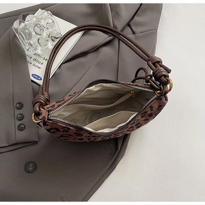 Détail du sac à bandoulière léopard en daim avec poignée à cordon et poches internes