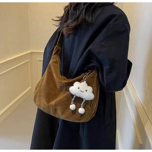 Brown suede hobo bag with cloud charm detail shown on model in stylish coat