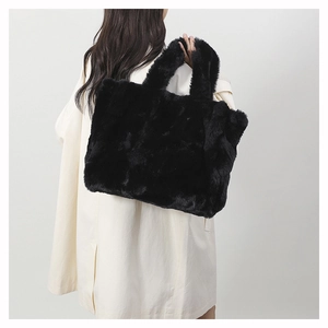 Gros plan sur la texture en fausse fourrure noire et la poignée en peluche du sac à main