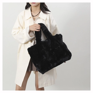 Détail d'un grand cabas noir en fausse fourrure avec texture douce et doubles poignées