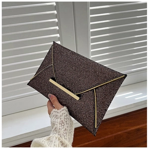 Détail de la pochette enveloppe scintillante marron foncé avec bordure dorée élégante