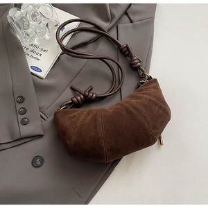 Sac croissant en daim marron foncé avec coutures segmentées et bandoulière nouée élégante