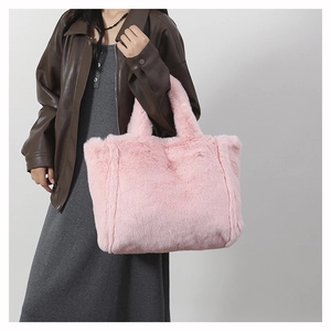 Gros plan sur un sac à main en peluche rose doux avec des anses en fausse fourrure