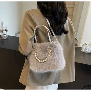 Detail of grey faux fur crossbody bag with elegant pearl chain strap and soft texture
