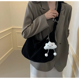 Detail of black velvet crescent bag with a cute white cloud plush pendant and silver buckle