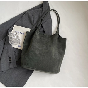 Minimalist large olive green suede tote bag for women shown in a flat lay lifestyle shot