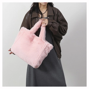 Gros plan détaillé montrant la texture douce en fausse fourrure rose du sac à main