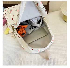 Vue détaillée de l'intérieur du sac à dos cerise en velours blanc avec ses rangements