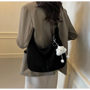 Detail of black crescent shoulder bag in matte PU leather with a cute cloud charm