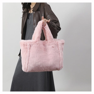 Détail du sac cabas en fausse fourrure rose montrant la texture douce et les poignées