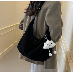 Minimalist black crescent shoulder bag with white plush cloud charm shown on model