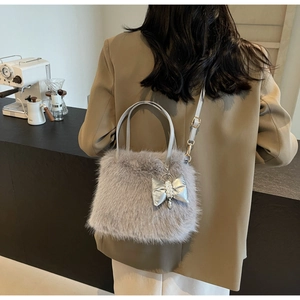 Detail of plush grey crossbody bag with silver satin bow and pearl charm pendant decor