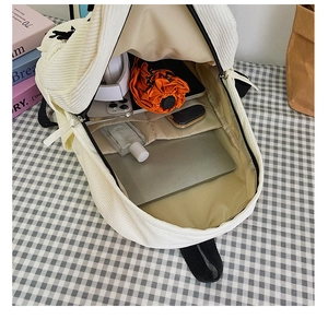 Vue de dessus d'un sac à dos en velours blanc montrant sa grande capacité interne