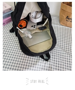 Détail de l'intérieur d'un sac à dos en velours côtelé avec compartiments pour ordinateur