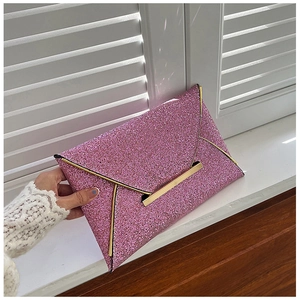 Vue détaillée d'une pochette enveloppe rose à paillettes avec des finitions dorées