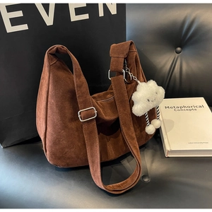 Minimalist caramel suede hobo bag with adjustable shoulder strap and plush cloud charm