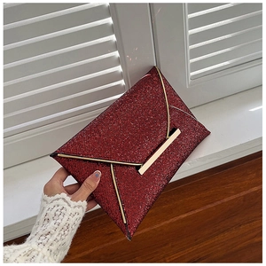 Détail de la pochette rouge à paillettes avec bordure dorée et fermoir métallique