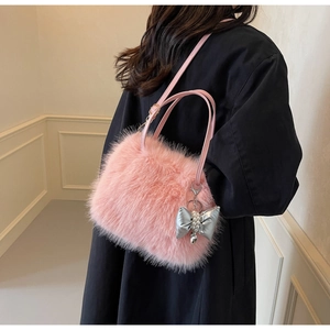 Detail of pink faux fur handbag with a silver bow and pearl pendant charm