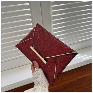 Détail d'une pochette enveloppe à paillettes rouges avec fermoir doré métallique