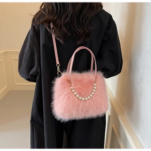 Detailed view of plush pink crossbody bag with pearl chain and adjustable shoulder strap