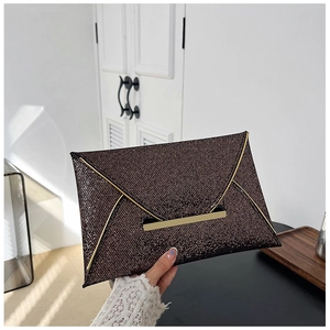 Détail de la pochette enveloppe bronze scintillante avec barre métallique dorée et paillettes