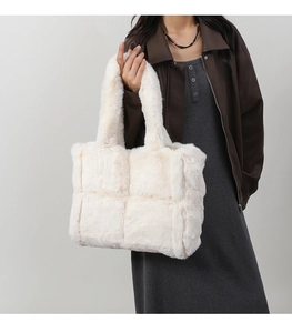 Detail of white faux fur tote bag showing plush quilted square texture and soft handle