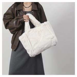 Détail d'un grand sac cabas blanc en fausse fourrure pelucheuse porté par un mannequin