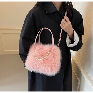 Detail of pink faux fur crossbody bag featuring elegant white pearl embellishments