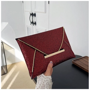 Détail d'une pochette enveloppe à paillettes rouges avec bordure dorée métallique