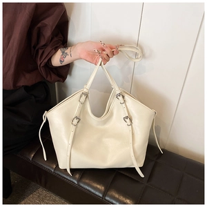 Detailed view of cream PU leather tote bag with silver metal buckle strap accents