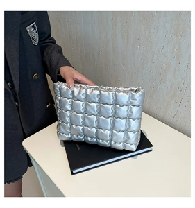 Détail d'une pochette argentée matelassée en PU effet bulle avec finition brillante