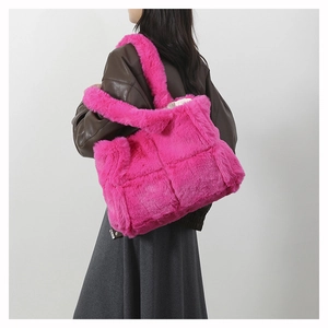 Détail d'un sac cabas en fausse fourrure rose matelassée montrant la texture douce