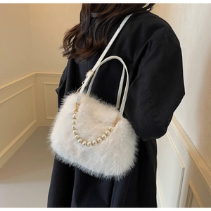 Close-up of white plush crossbody bag featuring elegant pearl chain and leather strap