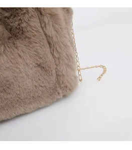 Detail of plush faux fur shoulder bag texture with gold chain strap in dark apricot