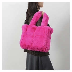 Close-up of bright pink plush tote bag with quilted square texture on shoulder