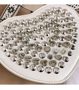 Gros plan sur le sac en forme de cœur blanc en cuir PU avec détails en strass brillants