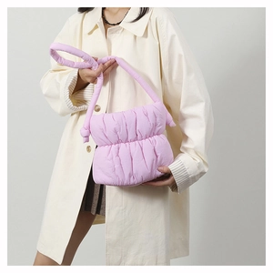 Detail of light purple quilted puffer bucket bag with knotted shoulder strap and soft texture