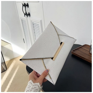 Détail de pochette enveloppe blanche scintillante avec bordure dorée et texture élégante