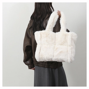Détail du sac cabas en fausse fourrure blanche montrant la texture douce et le porté épaule