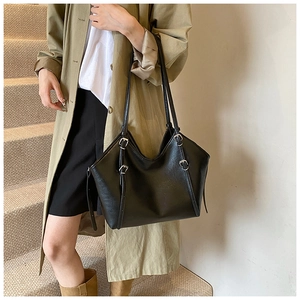 Detail shot of the glossy black PU tote bag showing silver metal buckle and soft texture
