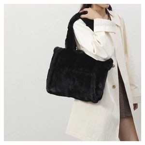 Détail d'un sac cabas en fausse fourrure noire montrant la texture douce sur un manteau