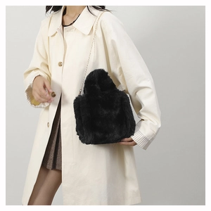 Close-up of black plush shoulder bag featuring gold chain strap and soft faux fur texture