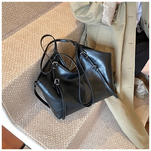 Close-up of black PU leather tote bag with silver buckle details and matte texture finish