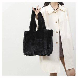 Détail d'un sac cabas en fausse fourrure noire avec texture douce porté par un mannequin