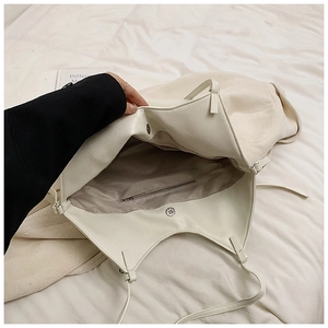 Detail view of white PU leather and corduroy patchwork bag with magnetic closure