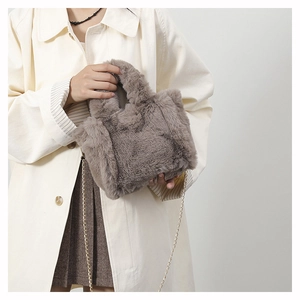 Close-up of fluffy brown plush crossbody bag with delicate metal chain strap detail