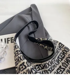 Detailed close-up of knitted tote bag with jacquard bear pattern and black leather trim