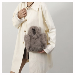 Detail view of a soft plush faux fur crossbody bag with golden chain strap for women