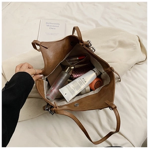 Internal view of spacious brown tote bag showing compartments filled with cosmetics