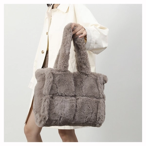 Detailed shot of grey plush tote bag featuring soft quilted faux fur and a fuzzy handle